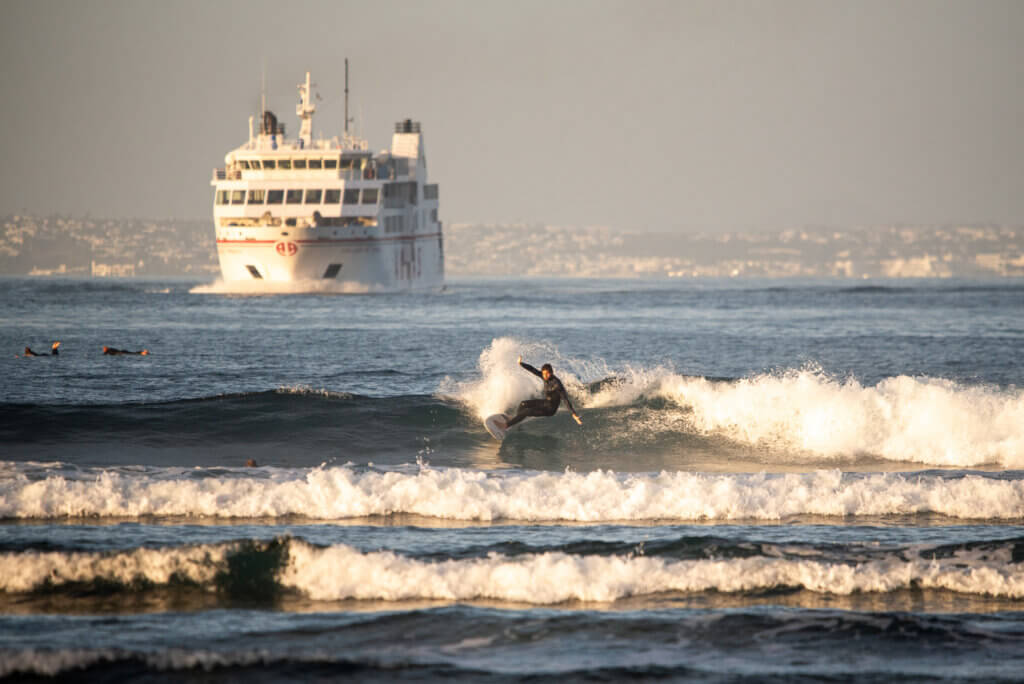 surfer riding a wave at sunset during a surf session